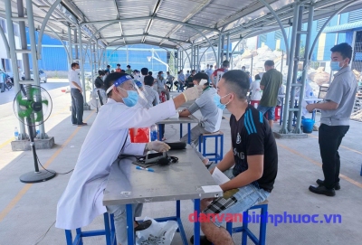 Các nhân viên y tế đo huyết áp, làm các bước kiểm tra trước lúc vào phòng tiêm