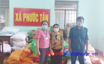 Đồng chí Nguyễn Thị Kim Trúc- Phó Chủ tịch UBND xã Phước Tân (bên trái)  tiếp nhận 100 phần quà từ Ủy ban MTTQ Việt Nam huyện  để trao cho các hộ dân gặp khó khăn trong khu vực phong tỏa