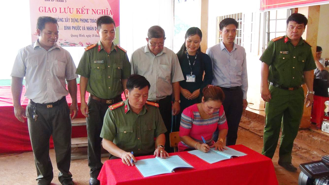 Trung tá Đào Văn Thêm - Trưởng phòng Xây dựng phong trào bảo vệ ANTQ  và bà Thị Phương, Trưởng ấp Tranh 3 ký kết giao ước kết nghĩa trước sự chứng kiến của lãnh đạo xã Quang Minh