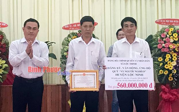 Lãnh đạo huyện Lộc Ninh nhận bảng tượng trưng số tiền các doanh nghiệp ủng hộ quỹ “vì người nghèo” (Ảnh Báo Bình Phước Online)