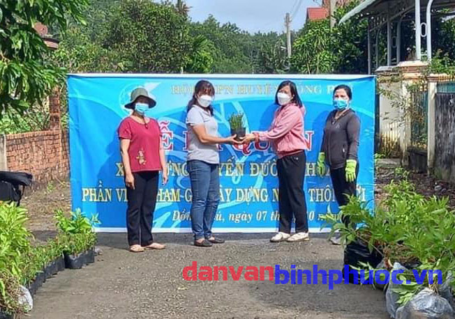Bà Nguyễn Thị Xim, Chủ tịch Hội LHPN huyện Đồng Phú trao tặng số hoa tại buổi lễ ra quân trồng tuyến đường hoa Nông thôn mới kiểu mẫu