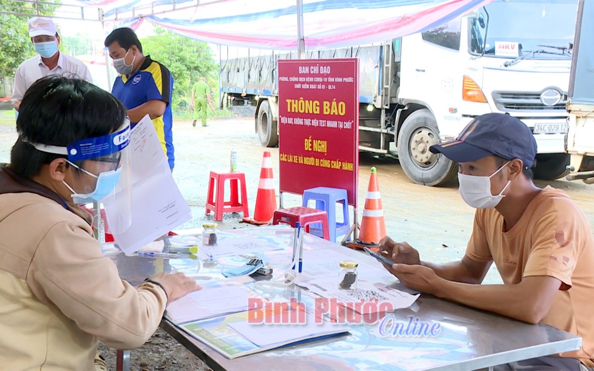 Người dân TP. Hồ Chí Minh và các tỉnh Bình Dương, Đồng Nai, Long An khai báo y tế tại chốt kiểm soát trước khi vào Bình Phước. Nguồn ảnh: Báo Bình Phước Online