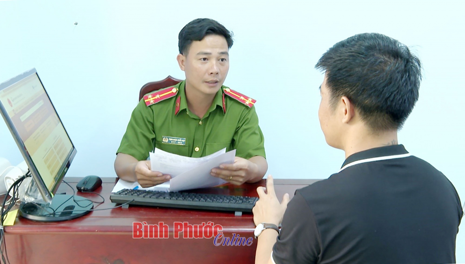 Cán bộ Công an xã Tân Hưng, huyện Đồng Phú hướng dẫn người dân giải quyết thủ tục hành chính trên cổng dịch vụ công trực tuyến (Ảnh: Báo Bình Phước online)