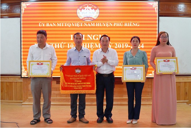 Anh Nguyễn Anh Đức (đứng thứ 2 từ trái sang) nhận cờ thi đua của Ủy ban MTTQ Việt Nam huyện năm 2022