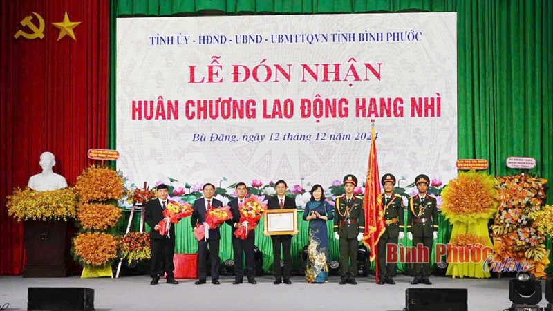 ồng chí Huỳnh Thị Hằng Phó Bí thư Thường trực Tỉnh ủy, Chủ tịch HĐND tỉnh, thừa ủy quyền của Chủ tịch nước trao Huân chương Lao động hạng Nhì và tặng hoa chúc mừng Đảng bộ, chính quyền và nhân dân huyện Bù Đăng. (Ảnh: Bình Phước Online)